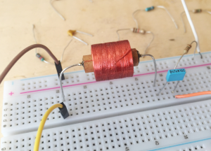 Circuit RLC utilisé pour mesurer l'inductance d'une bobine. Le multimètre est placé en parallèle de la résistance (fils orange et blanc). Le générateur est branché en série dans le circuit (fils jaune et marron).